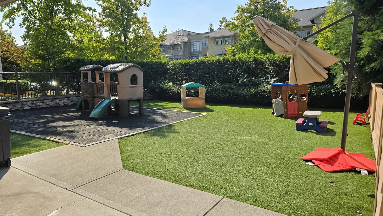 the infant and toddler playground with a climber, slides, playhouses and soft turf